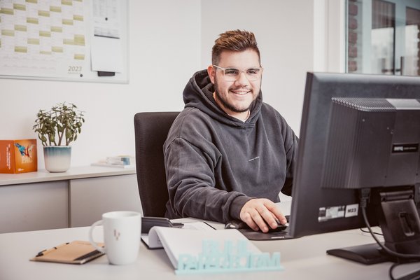 Porträt eines lächelnden Mitarbeiters am Büro Arbeitsplatz